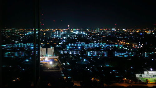 Illuminated cityscape against sky at night