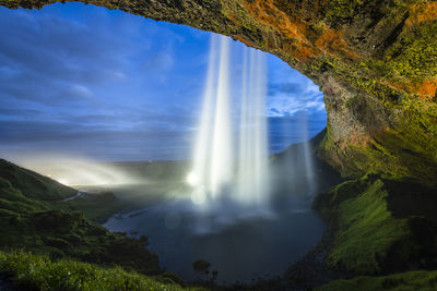 Low angle view of waterfall against sky