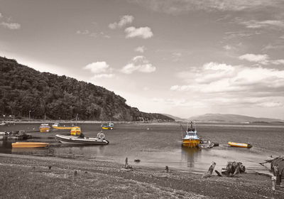 Sailboats moored in lake against sky