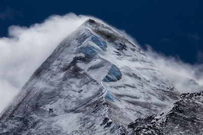 Low angle view of snowcapped mountain against sky