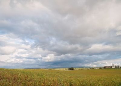 Scenic view of agricultural field against dramatic sky