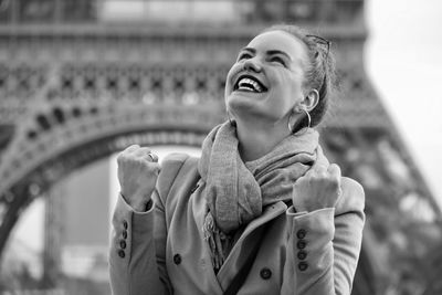 Low angle view of smiling young woman looking up