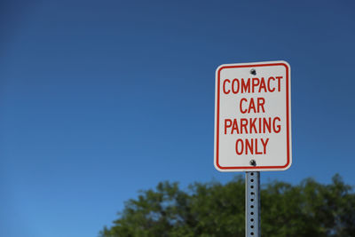 Parking sign against clear blue sky