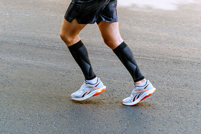 Low section of woman walking on road