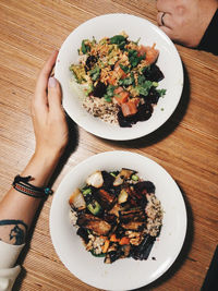 High angle view of person hand on table with salad bowl