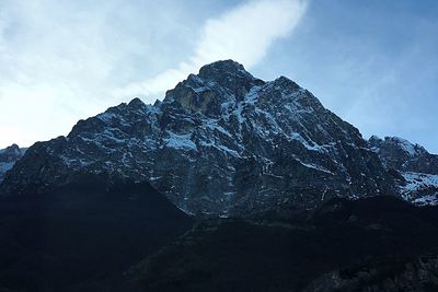 Road leading towards snowcapped mountain against sky