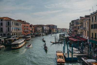 Boats in canal amidst buildings in city