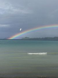 Scenic view of rainbow over sea against sky