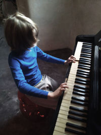 Rear view of girl playing piano