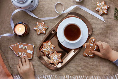 Kid takes christmas gingerbread cookies. atmospheric festive christmas decorations with hot cocoa. 