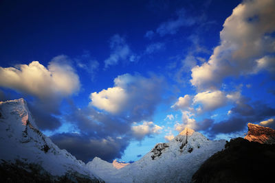 Low angle view of mountain range against cloudy sky 