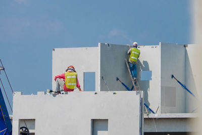 Low angle view of worker working at construction site against sky