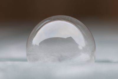 Close-up of glass on table against white background