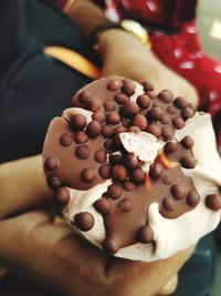 Close-up of hand holding chocolate cake