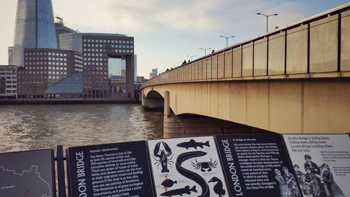 Bridge over river against buildings in city