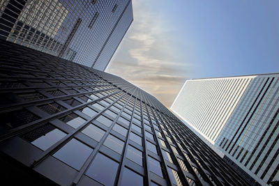 Low angle view of modern glass building against sky