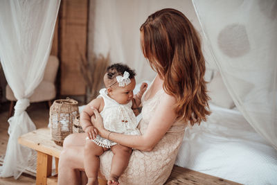 Mother and girl sitting at home