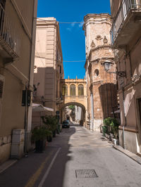 Empty road amidst buildings in city