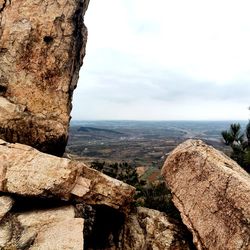 Scenic view of rocks by sea against sky