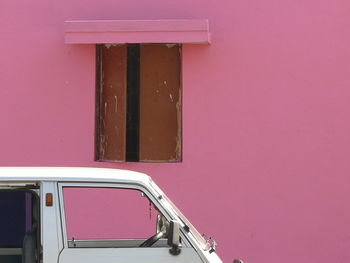White van against pink house