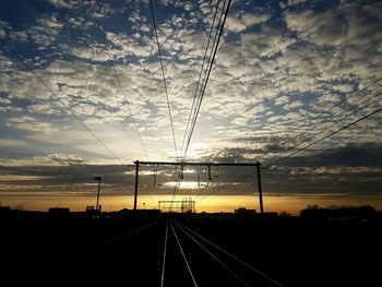 Railroad tracks against sky during sunset