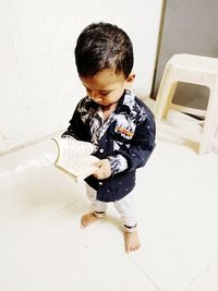 High angle view of cute boy reading book at home