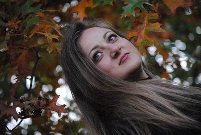 Portrait of beautiful young woman with autumn leaves