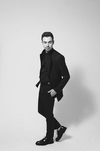 Portrait of young man standing against white background