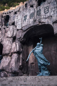 Low angle view of statue against stone wall