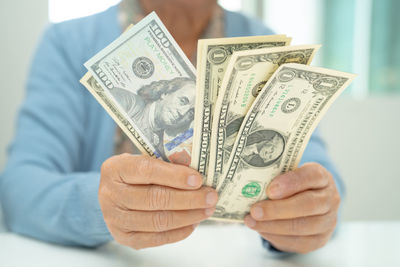 Midsection of man holding paper currency