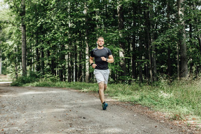 Full length of young man running in forest
