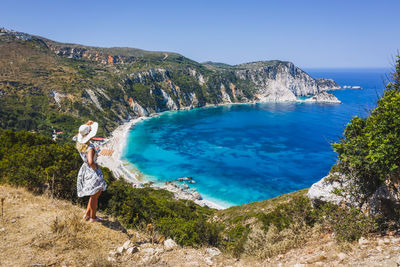 Scenic view of sea and mountains against blue sky