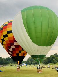 Hot air balloons on land against sky