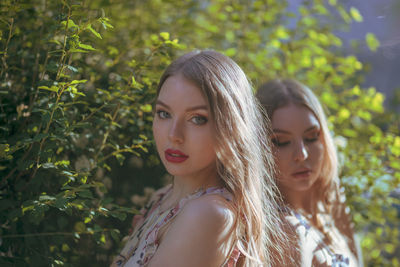 Portrait of beautiful woman with friends standing in park