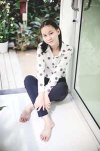 Portrait of young woman sitting on floor