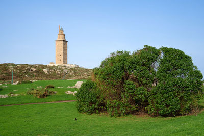 Trees and lighthouse against sky