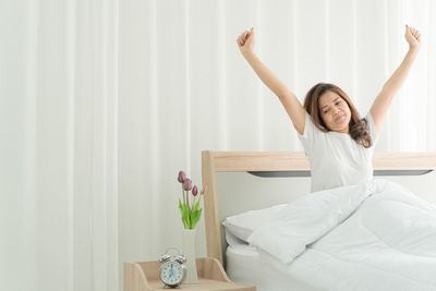 Young woman smiling while relaxing on bed at home