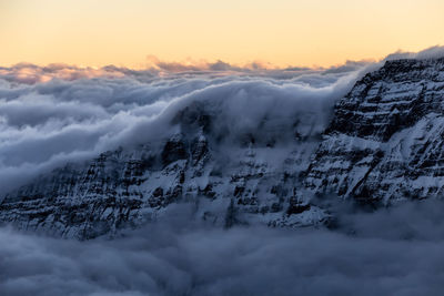 Scenic view of snow covered mountains against sky during sunset