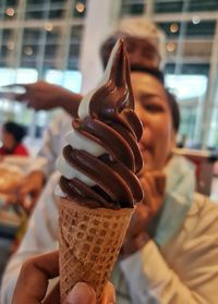 Close-up of hand holding ice cream cone