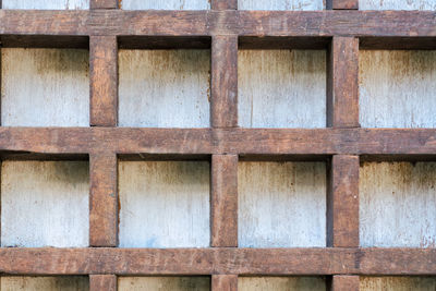 Old wooden cells on a white wall. vintage brown background.
