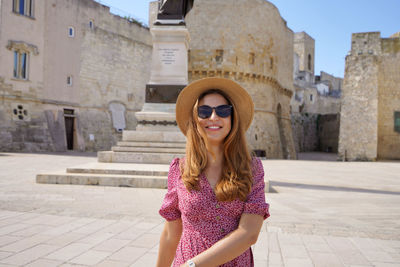 Portrait of beautiful woman wearing sunglasses standing outdoors