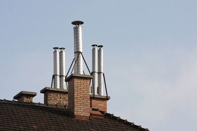 Low angle view of chimney on roof against clear sky