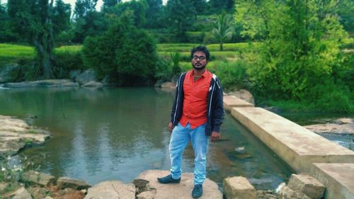 Portrait of smiling man standing on riverbank