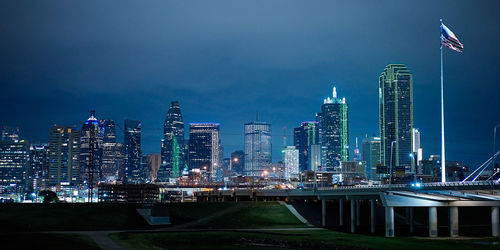 Illuminated cityscape against sky at night