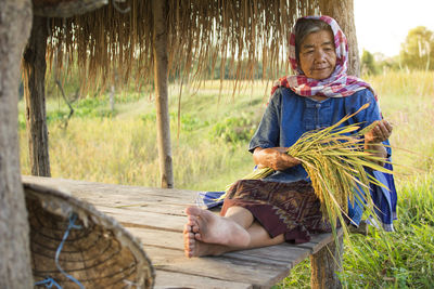 Senior woman sitting in shed at farm