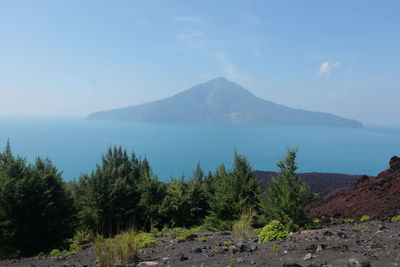 Scenic view of sea and mountains against sky