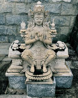 Close-up of buddha statue against wall