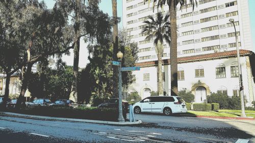 Cars on road by buildings in city