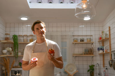 The young man is choosing whether to eat a healthy salad or bread.