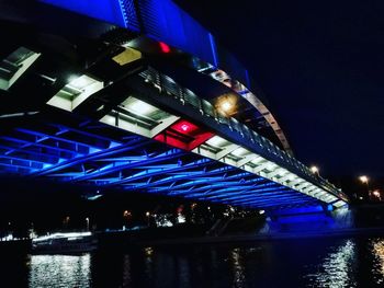 Low angle view of illuminated bridge over river at night